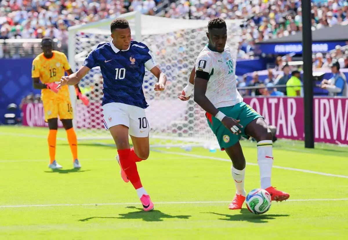 Kylian Mbappe chases Senegal's Moussa Niakhate in World Cup match