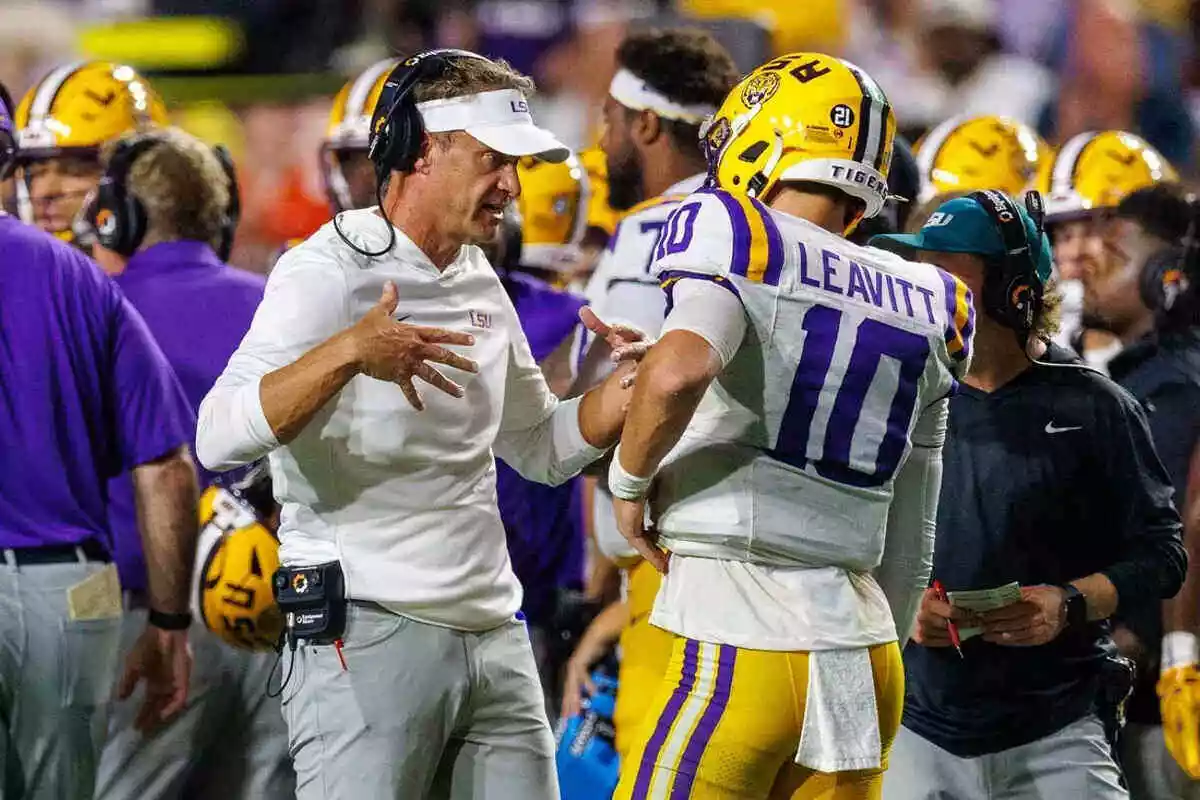 LSU coach Lane Kiffin and quarterback Sam Leavitt talk on the sideline