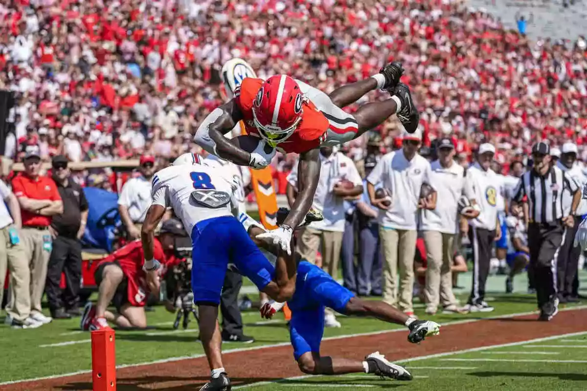 Georgia Bulldogs tight end Elyiss Williams hurdles Tennessee State Tigers safety Brendan Hale